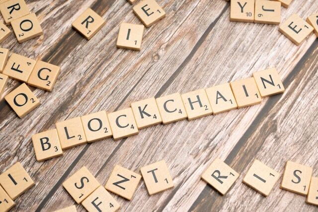 Wooden letter tiles spelling BLOCKCHAIN on wood